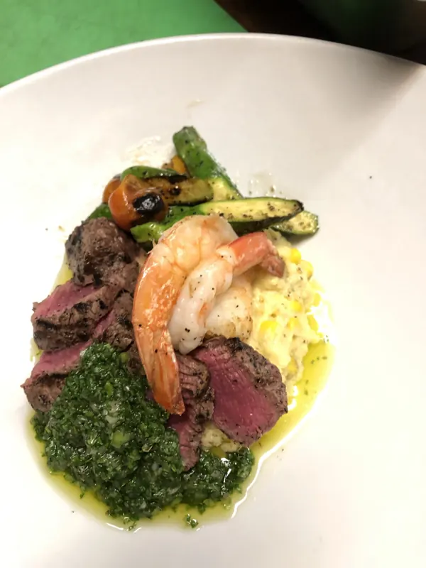Sliced steak and grilled shrimp with chimichurri